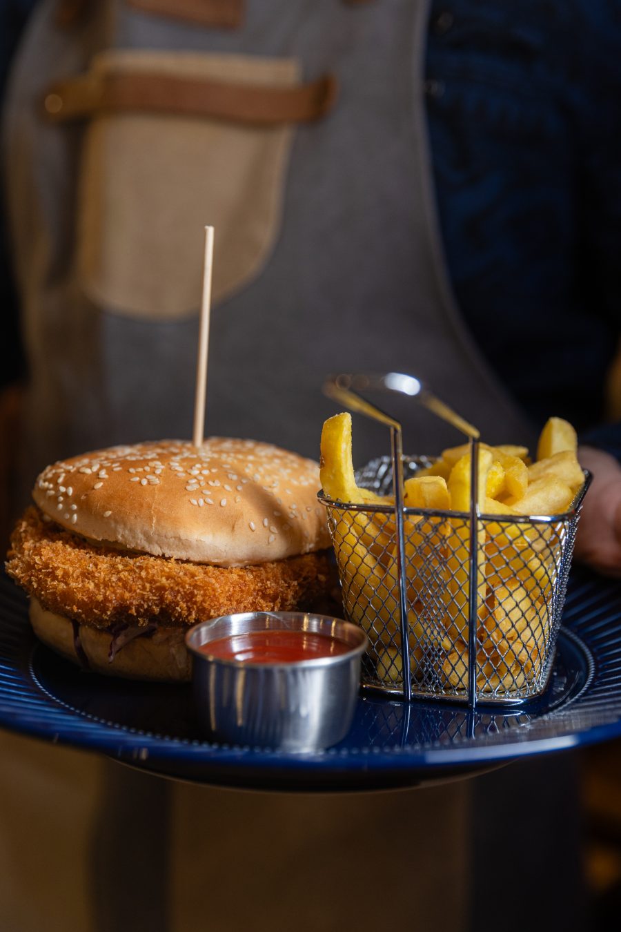 Burger sa pomfritom i sosom na tanjiru