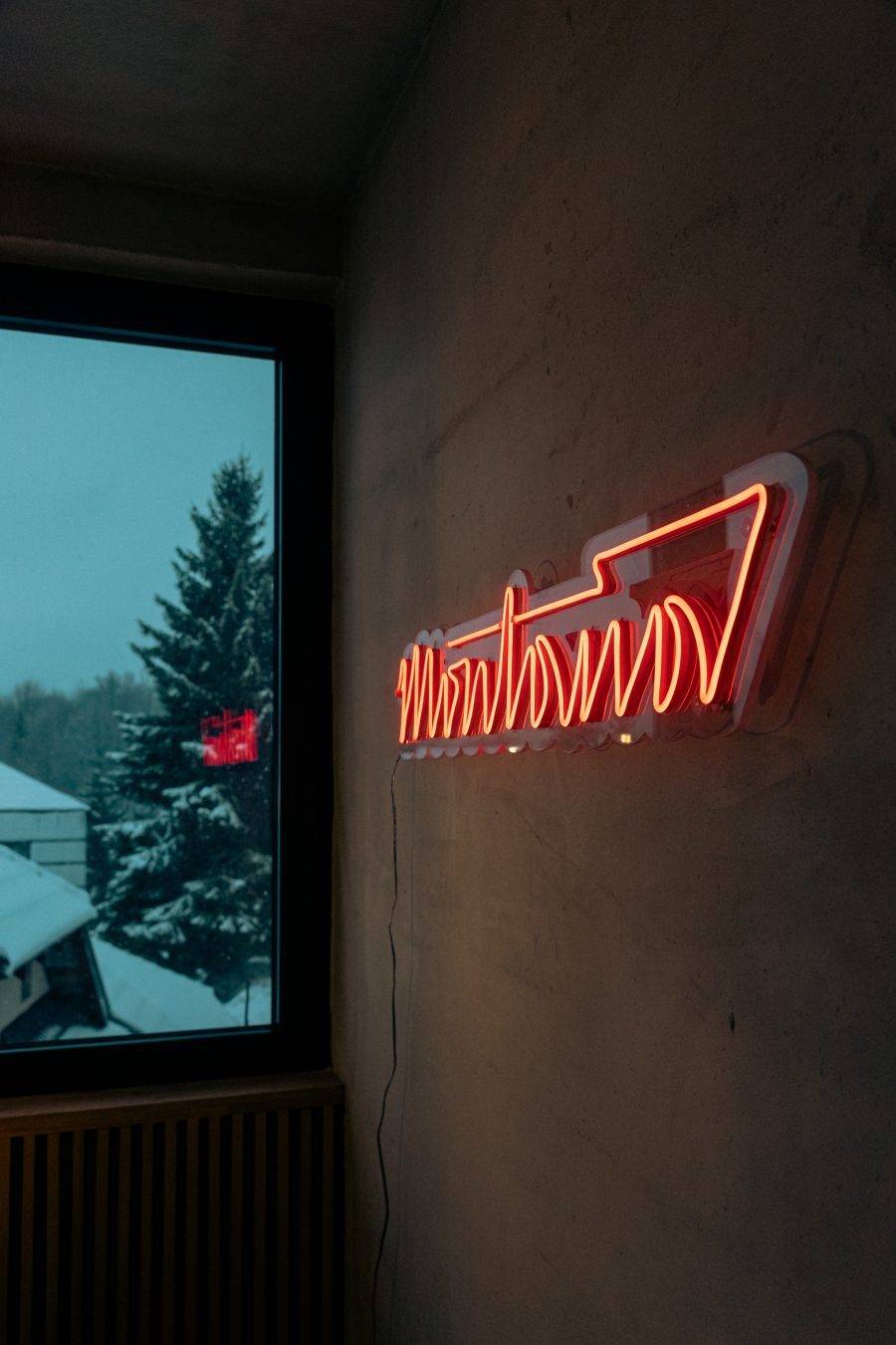 Neonski natpis Montana i prozor sa pogledom na sneg