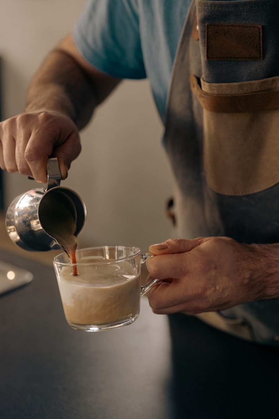 Barista sipa mleko u kafu