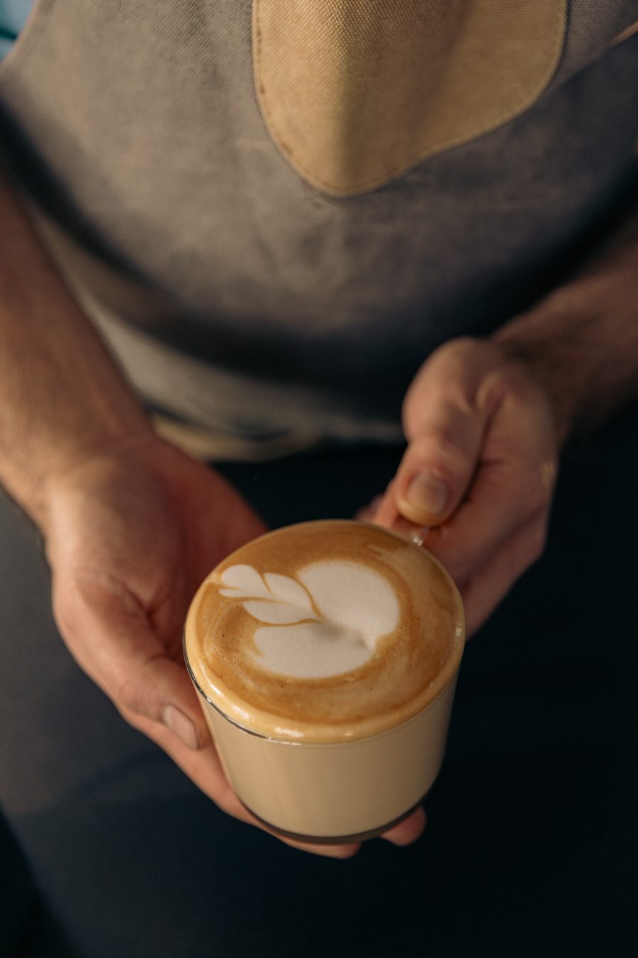 Kapućino sa latte art srcem u rukama