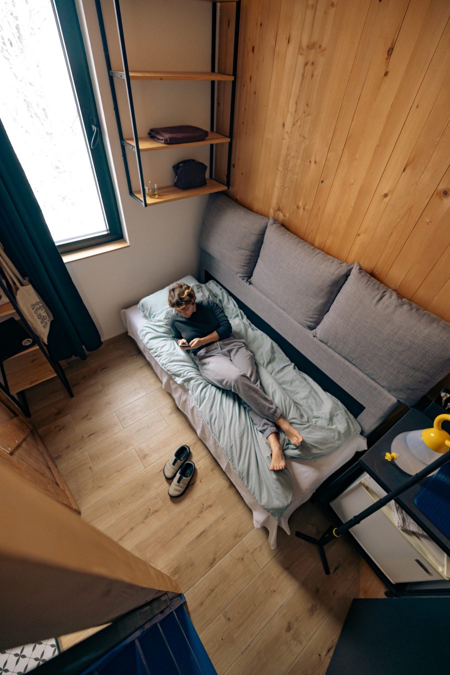 Montana Loft – gost se odmara na krevetu pored prozora