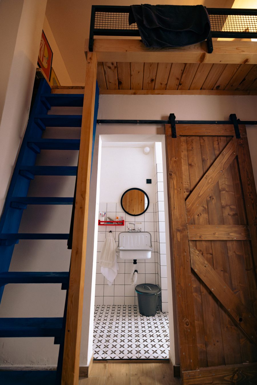 Montana Loft – plave stepenice ka galeriji i klizna vrata kupatila