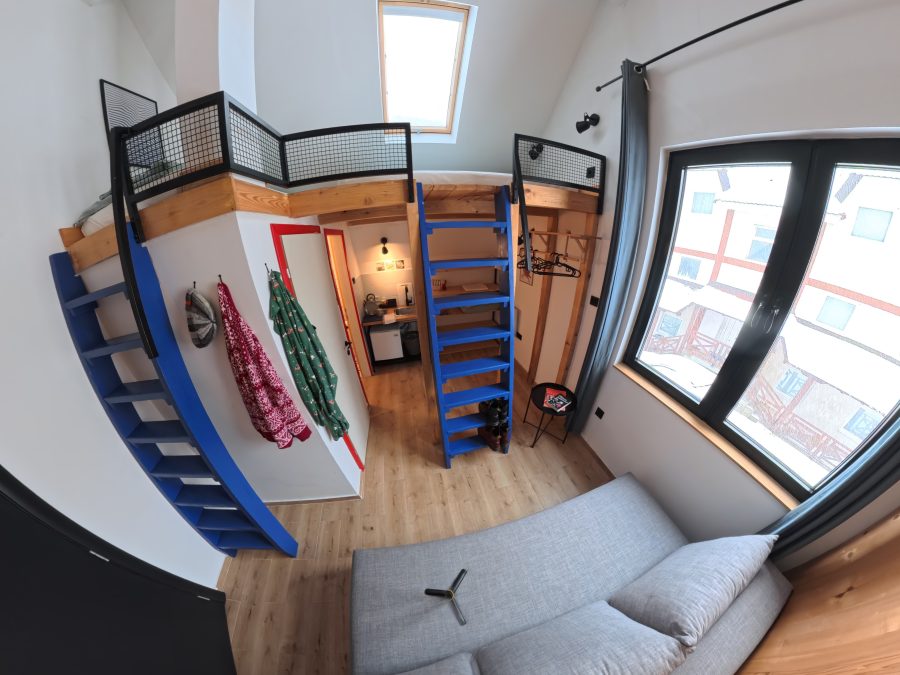 Montana Nook – soba sa galerijom za spavanje, plavim merdevinama i sofom, pogled odozgo