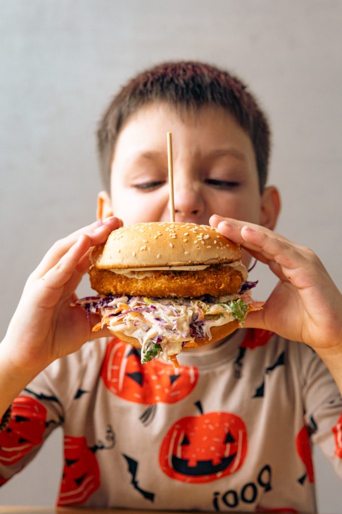 Dečak jede veliki burger